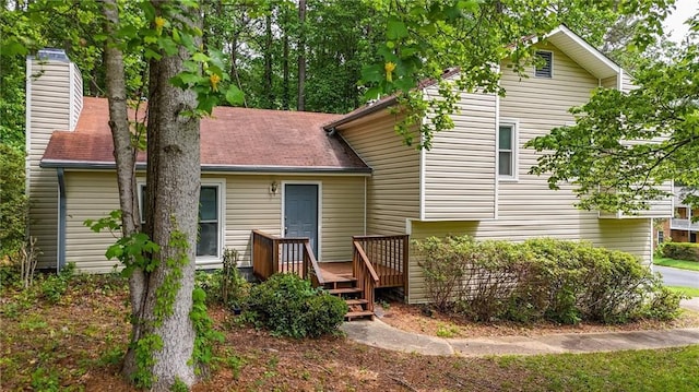 rear view of property with a wooden deck and a chimney