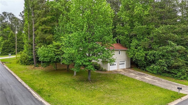 obstructed view of property with an attached garage, driveway, and a front lawn