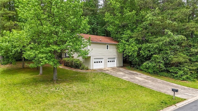 view of front of property with an attached garage, concrete driveway, and a front lawn