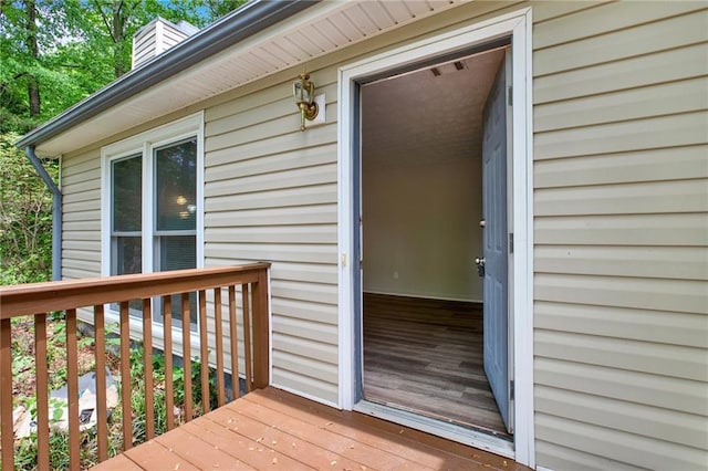 property entrance with a deck and a chimney