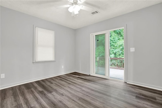 spare room with wood finished floors, healthy amount of natural light, a ceiling fan, and a textured ceiling