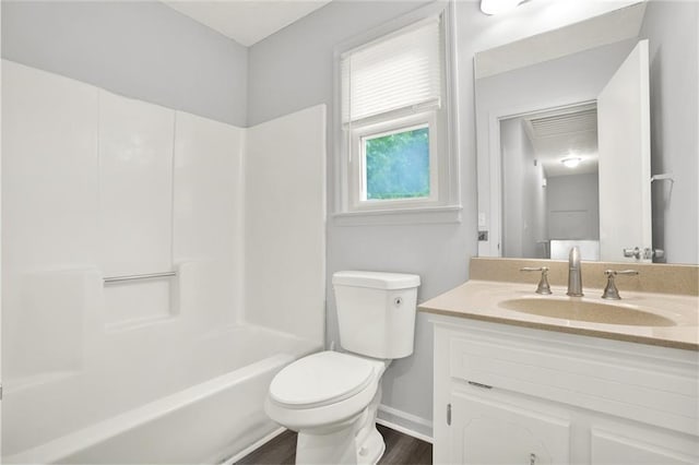 bathroom featuring toilet, baseboards, wood finished floors, vanity, and bathing tub / shower combination