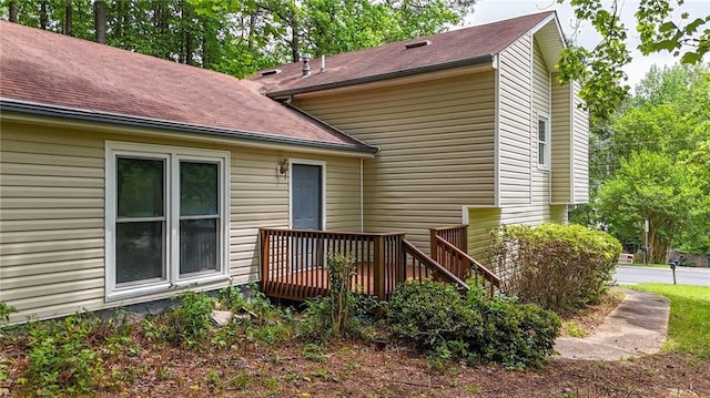 back of house featuring a deck and a shingled roof