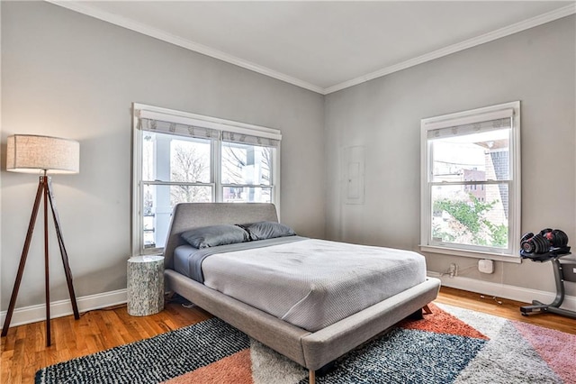 bedroom with baseboards, multiple windows, and wood finished floors