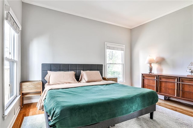 bedroom with crown molding and wood finished floors