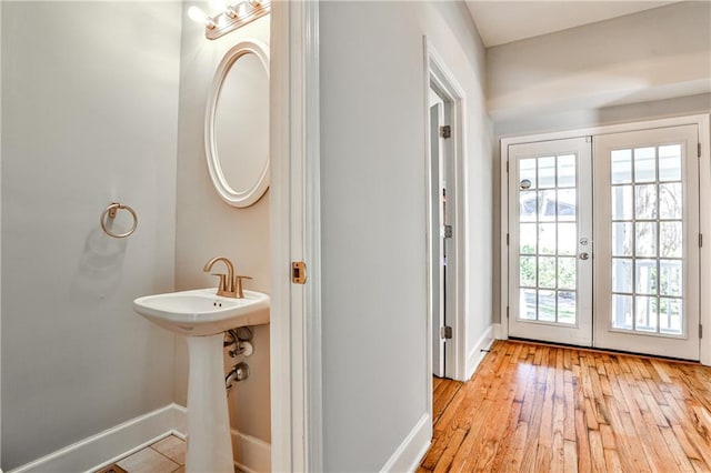 bathroom with french doors, baseboards, and hardwood / wood-style flooring