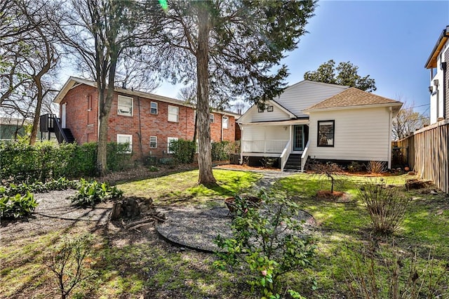 back of house featuring covered porch and fence