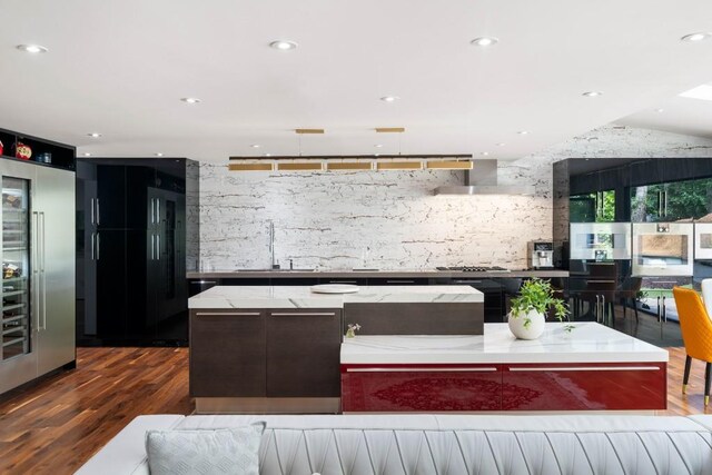 4070 Whitewater Creek Rd, Atlanta, GA 30327 - kitchen with wood finished floors, exhaust hood, light stone counters, a kitchen island, and recessed lighting