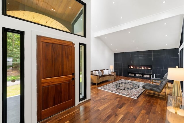 4070 Whitewater Creek Rd, Atlanta, GA 30327 - entrance foyer featuring wood finished floors, a warm lit fireplace, an accent wall, high vaulted ceiling, and recessed lighting