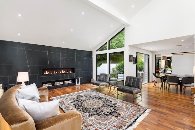 4070 Whitewater Creek Rd, Atlanta, GA 30327 - living room with high vaulted ceiling, a fireplace, wood finished floors, recessed lighting, and an accent wall