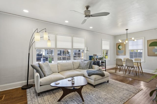 living room featuring ceiling fan with notable chandelier and wood-type flooring