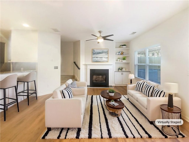 living room featuring ceiling fan and light wood-type flooring