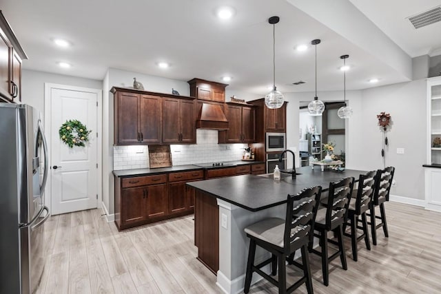 310 Chatuge Dr, Hoschton, GA 30548 - kitchen featuring stainless steel appliances, dark countertops, custom range hood, light wood finished floors, and recessed lighting