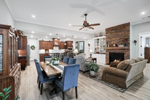 310 Chatuge Dr, Hoschton, GA 30548 - dining room featuring ceiling fan, light wood finished floors, a fireplace, recessed lighting, and crown molding