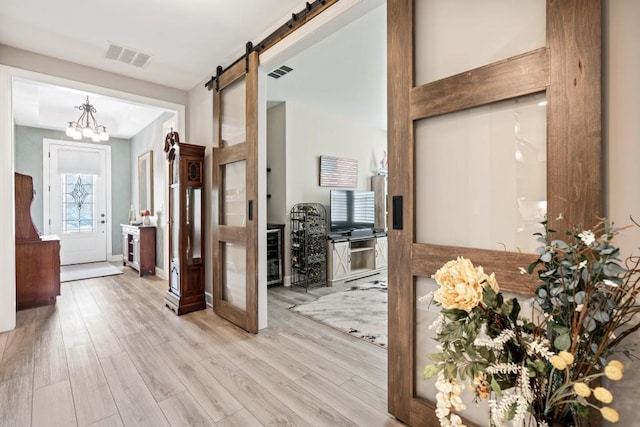 310 Chatuge Dr, Hoschton, GA 30548 - corridor featuring a barn door, wood finished floors, and a chandelier