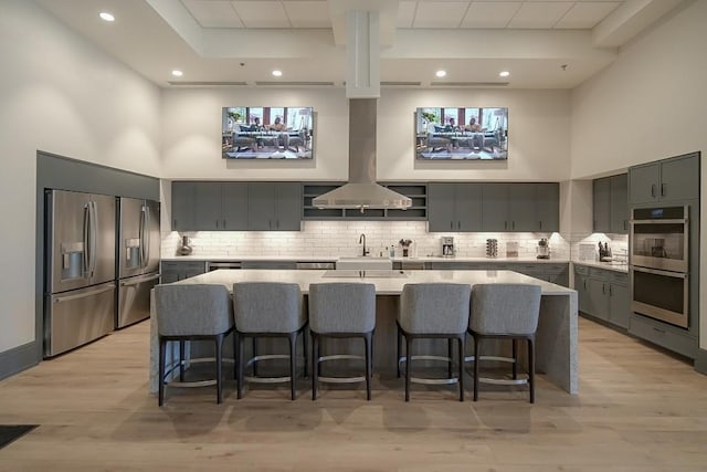 310 Chatuge Dr, Hoschton, GA 30548 - kitchen featuring appliances with stainless steel finishes, open shelves, gray cabinetry, decorative backsplash, and a kitchen bar