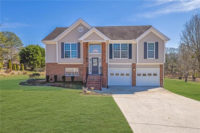 raised ranch featuring a garage, a front lawn, concrete driveway, and brick siding