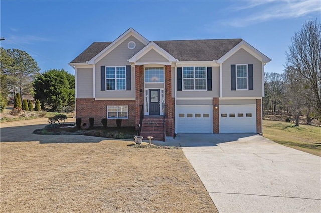 split foyer home featuring a garage, concrete driveway, and brick siding