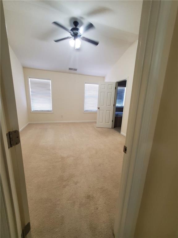 4215 Wildener Way, Cumming, GA 30041 - spare room featuring visible vents, baseboards, light colored carpet, and a ceiling fan