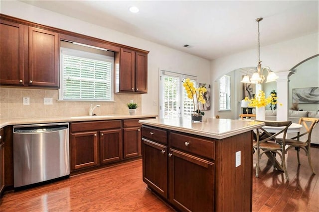 kitchen with stainless steel dishwasher, a healthy amount of sunlight, and hardwood / wood-style flooring