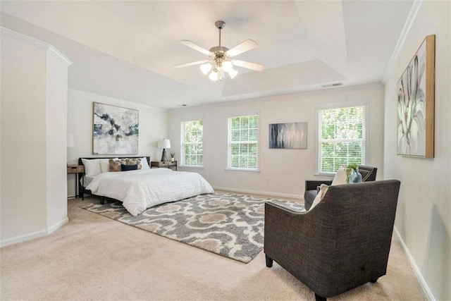 bedroom featuring ceiling fan, light carpet, and a tray ceiling