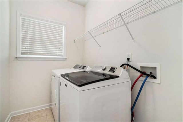 washroom with washing machine and dryer and light tile patterned flooring