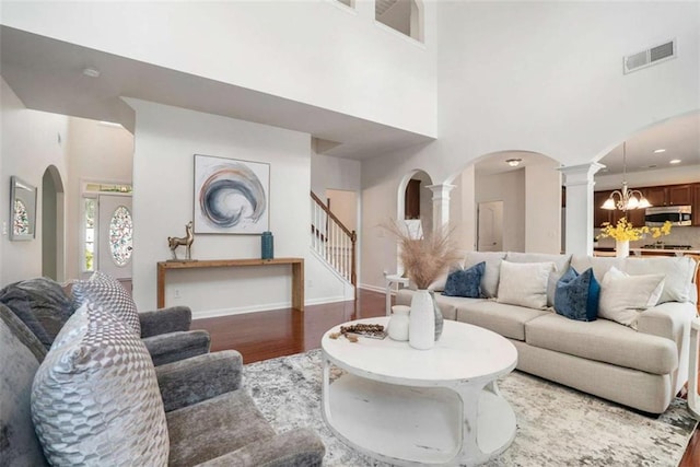 living room featuring a chandelier, a high ceiling, and dark wood-type flooring