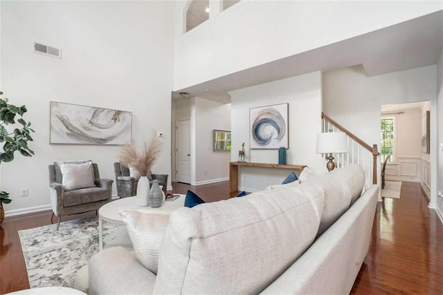 living room with dark hardwood / wood-style floors and a high ceiling