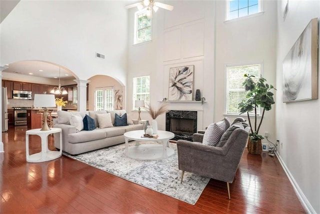 living room featuring a high ceiling, a wealth of natural light, and dark wood-type flooring