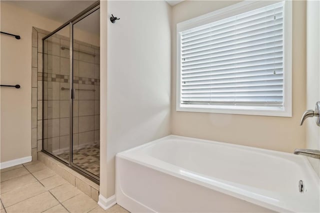 full bathroom featuring a stall shower, a bath, tile patterned floors, and baseboards