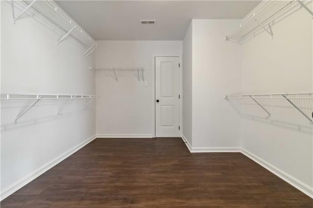 walk in closet with wood finished floors