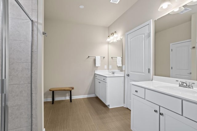 bathroom featuring a sink, visible vents, two vanities, and baseboards