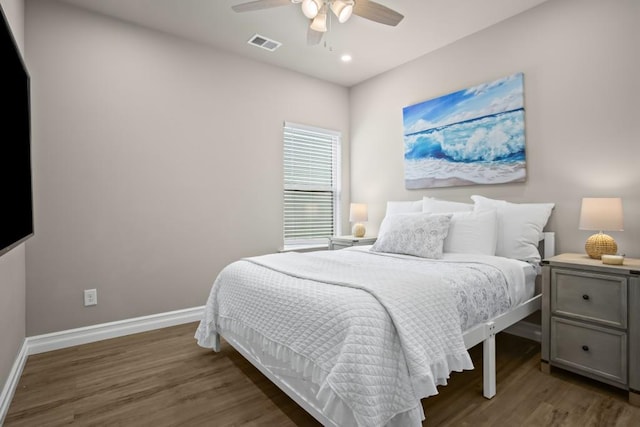 bedroom with ceiling fan, visible vents, baseboards, and wood finished floors