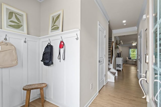 mudroom featuring a decorative wall, light wood-type flooring, and ornamental molding
