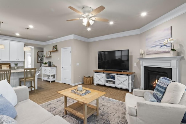living room featuring recessed lighting, crown molding, a ceiling fan, and wood finished floors
