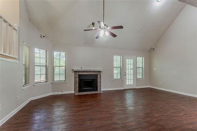 unfurnished living room with a ceiling fan, plenty of natural light, wood finished floors, baseboards, and high vaulted ceiling