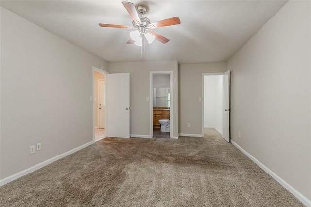 unfurnished bedroom with carpet, connected bathroom, baseboards, and a ceiling fan