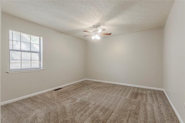 carpeted spare room with a ceiling fan, a textured ceiling, and baseboards