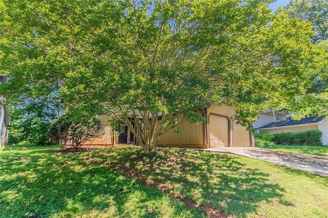 view of front facade with concrete driveway and a front lawn