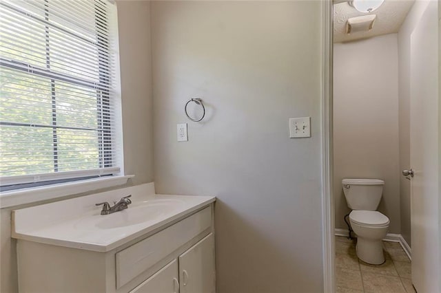 bathroom with vanity, toilet, tile patterned floors, and baseboards
