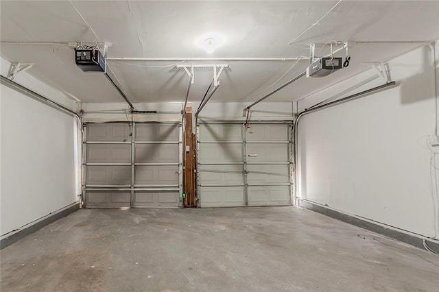 garage featuring a garage door opener and baseboards