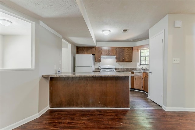 kitchen with freestanding refrigerator, exhaust hood, dark wood finished floors, light countertops, and a textured ceiling