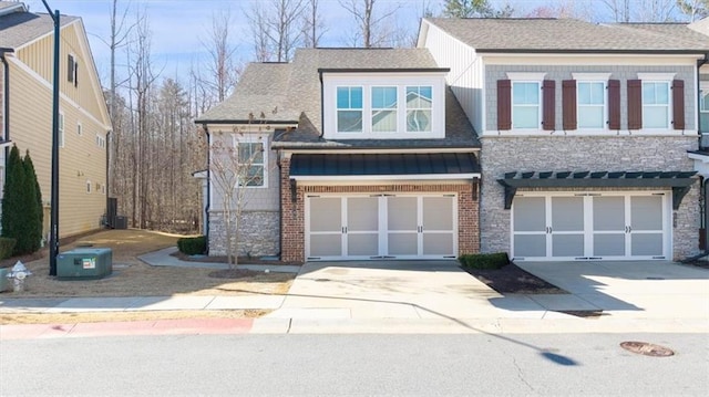 multi unit property with concrete driveway, brick siding, a garage, and a shingled roof