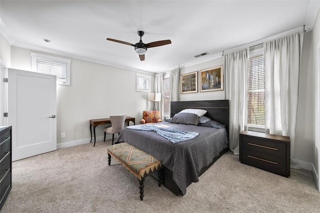 bedroom featuring visible vents, baseboards, ceiling fan, crown molding, and light colored carpet