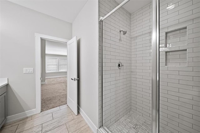 bathroom featuring a stall shower, vanity, and baseboards