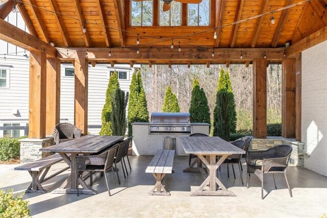 view of patio featuring a gazebo, an outdoor kitchen, a grill, and outdoor dining area