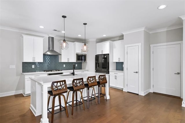 kitchen with a breakfast bar, stainless steel microwave, light countertops, and wall chimney exhaust hood