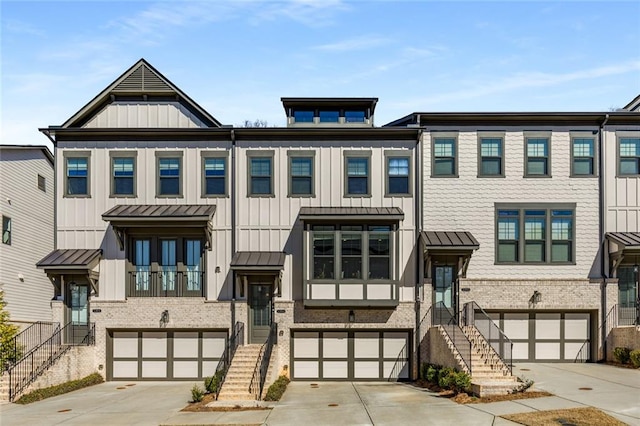 multi unit property featuring a standing seam roof, board and batten siding, and concrete driveway