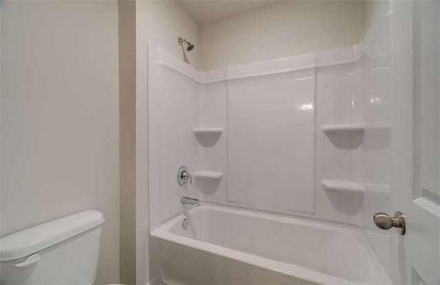full bath with washtub / shower combination and toilet