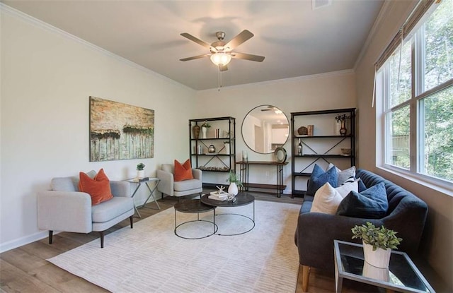 living area with ceiling fan, baseboards, ornamental molding, and wood finished floors